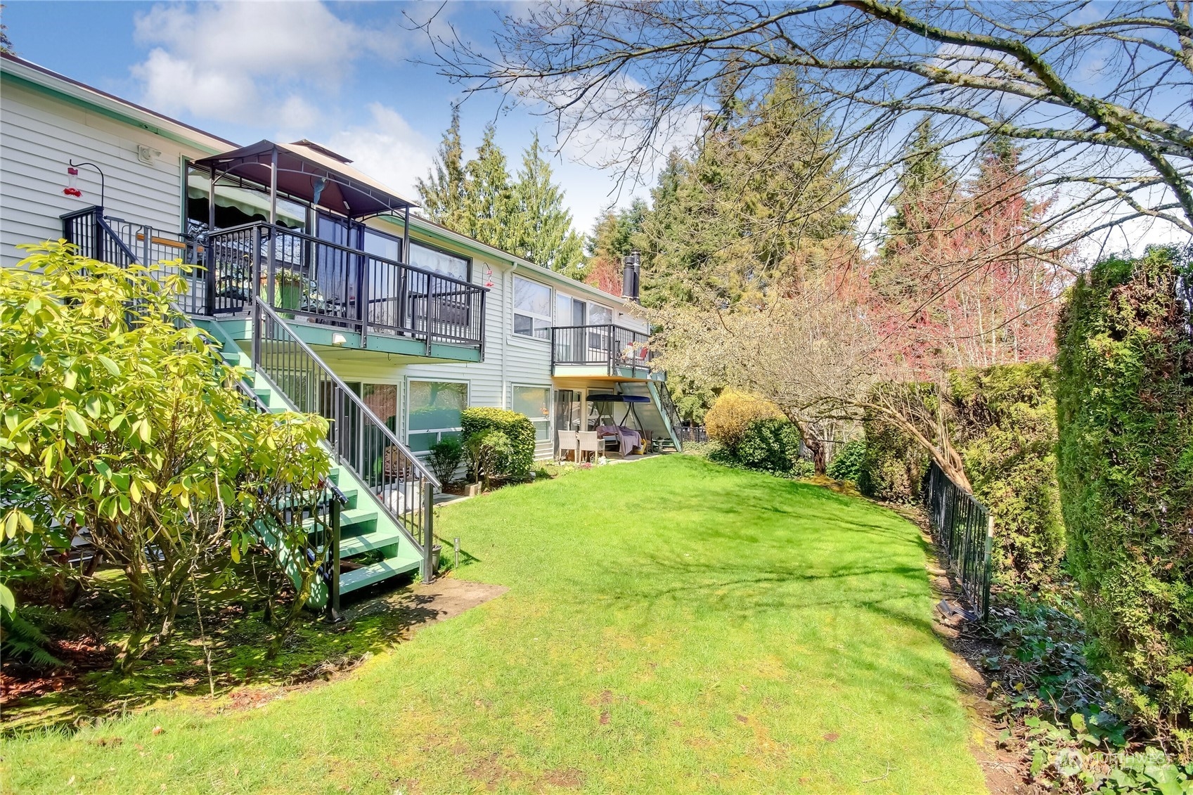2003 Southwest 318th Place, Unit D8 Federal Way, WA 98023 - Photo 19 of 35 a yellow house with flower garden in front of it