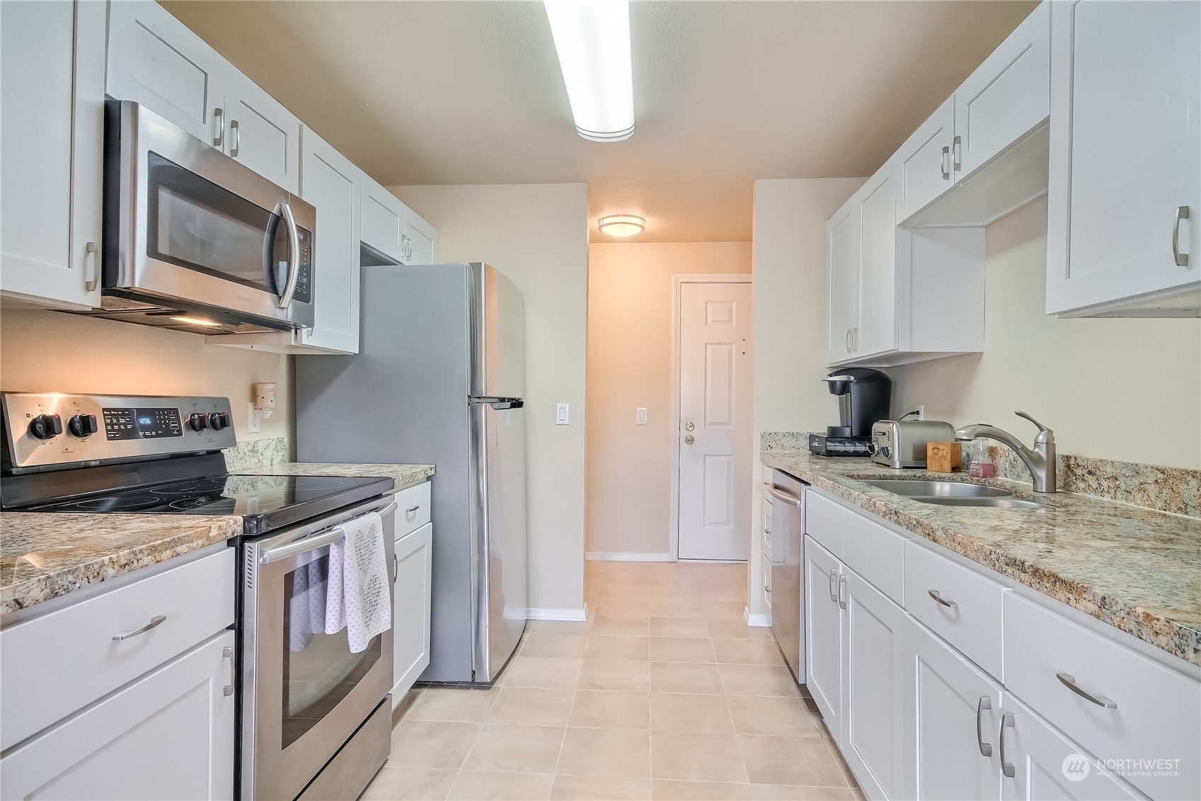 2003 Southwest 318th Place, Unit D8 Federal Way, WA 98023 - Photo 7 of 35 a kitchen with stainless steel appliances granite countertop a stove a sink and a microwave