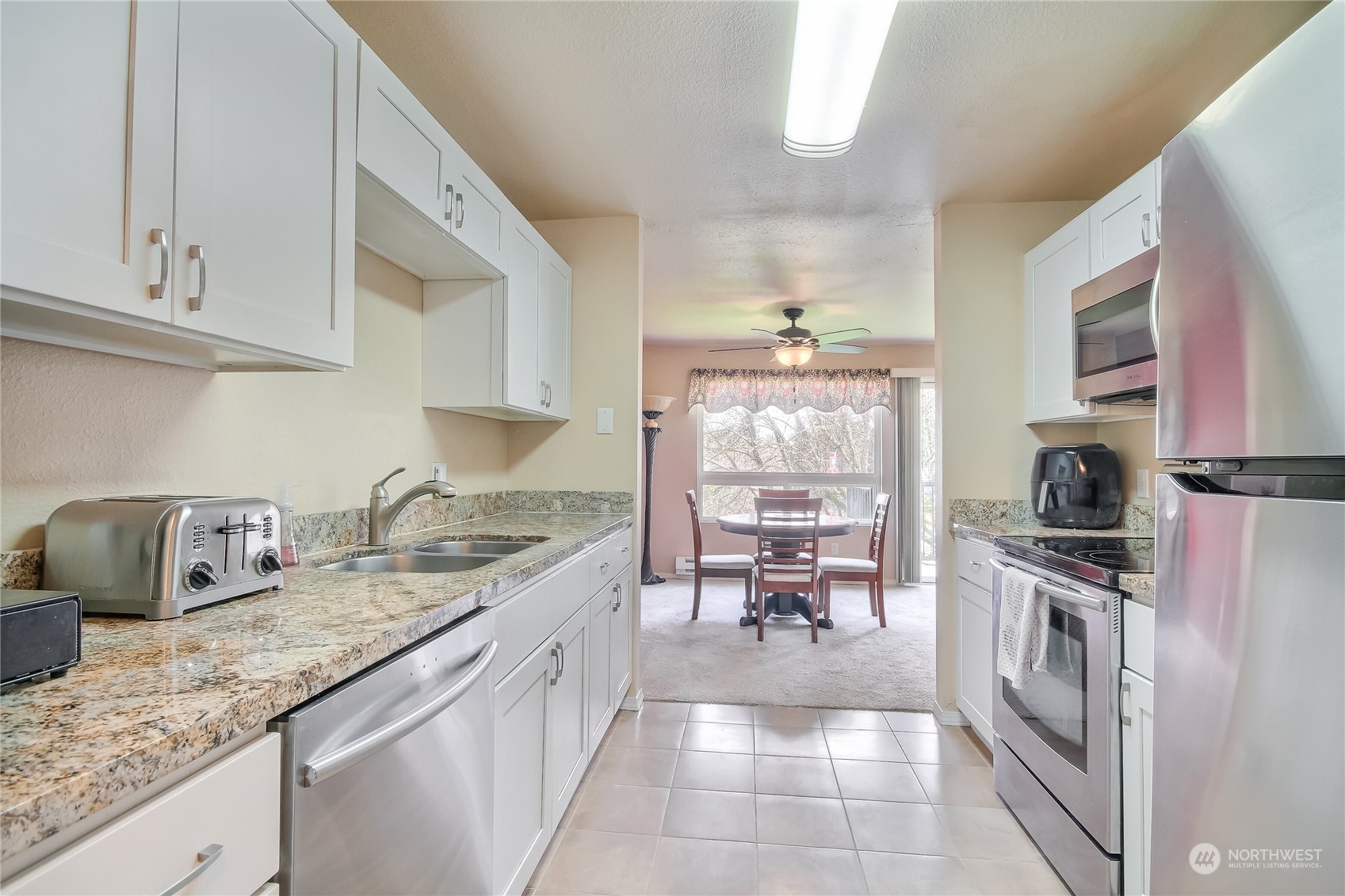 2003 Southwest 318th Place, Unit D8 Federal Way, WA 98023 - Photo 8 of 35 a kitchen with granite countertop a sink stove and cabinets