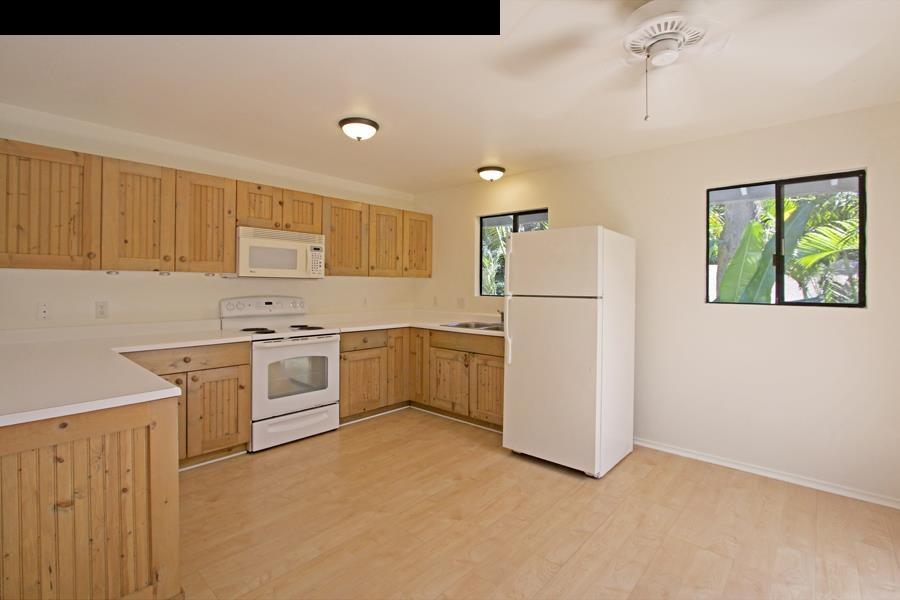 994 Kauhikoa Road Haiku, HI 96708 - Photo 5 of 13 a kitchen with white cabinets and white appliances