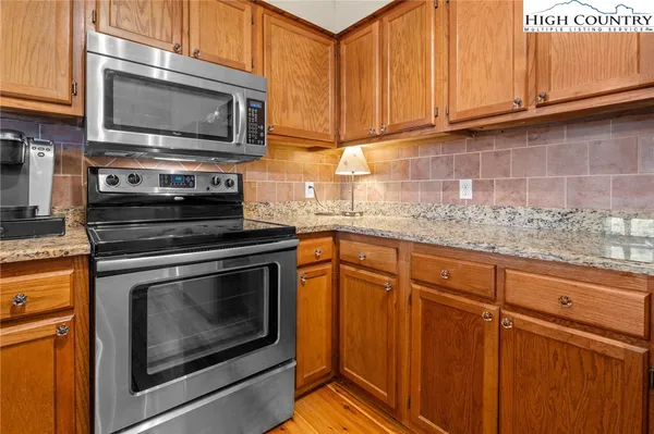 a kitchen with granite countertop cabinets stainless steel appliances and a sink