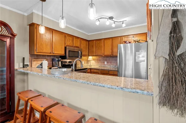 a kitchen with stainless steel appliances granite countertop a refrigerator a stove top oven a sink and dishwasher