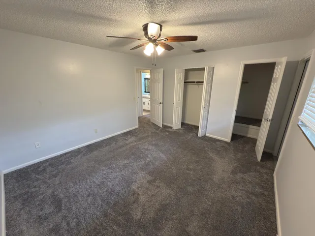 a view of an empty room with a ceiling fan
