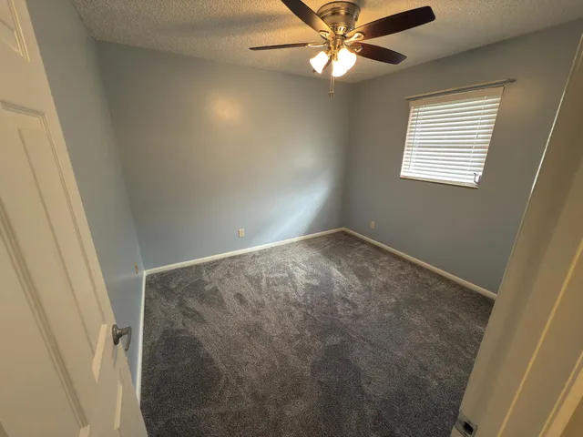 en empty room with windows and fan