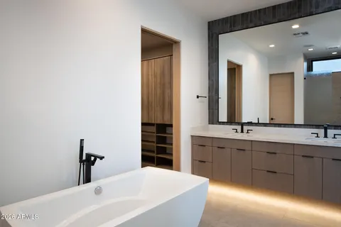 a bathroom with a tub sink and mirror