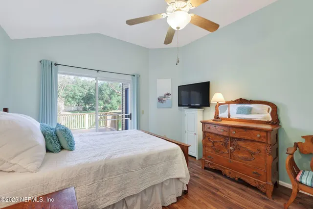a bedroom with a bed and a flat tv screen on dresser