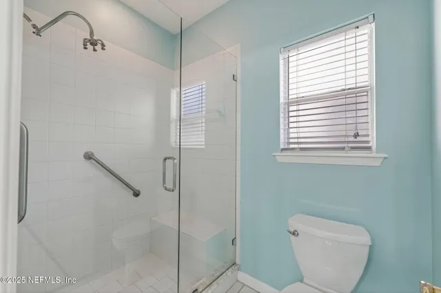a bathroom with a toilet and a shower