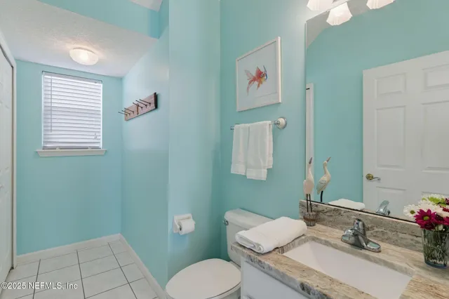 a bathroom with a granite countertop toilet sink and mirror