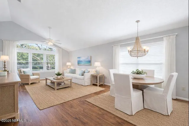 a living room with furniture chandelier and a table