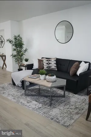 a living room with furniture potted plant and a mirror
