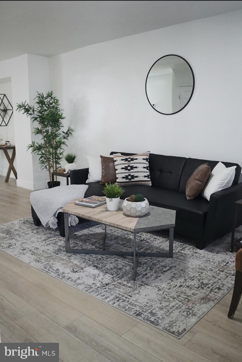 3516 Old York Road Baltimore, MD 21218 - Photo 1 of 1 a living room with furniture potted plant and a mirror