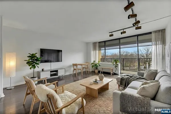 a living room with furniture a flat screen tv and a large window