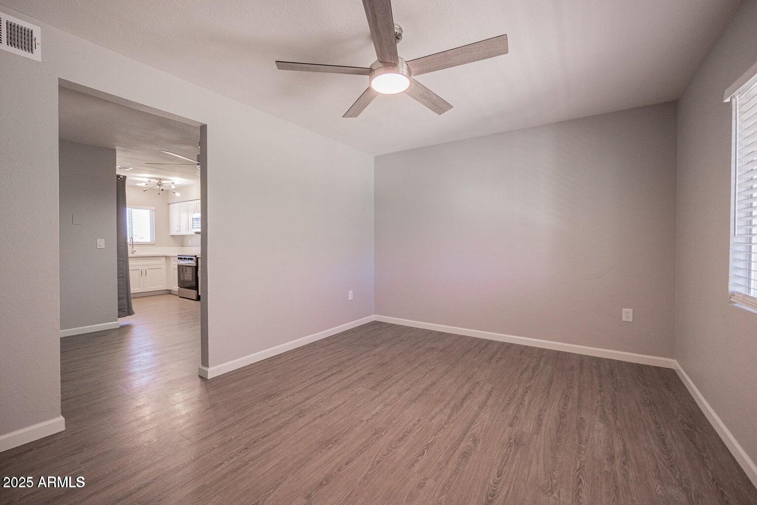 127 South Outpost Road, Unit 2 Apache Junction, AZ 85119 - Photo 2 of 14 wooden floor in an empty room with a window