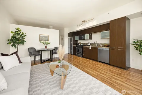a kitchen with stainless steel appliances kitchen island granite countertop a table chairs and a refrigerator
