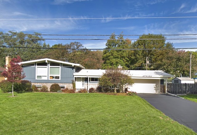 a front view of a house with a yard and a garage