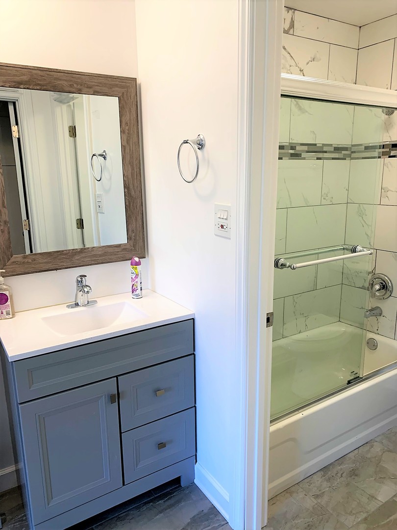 1741 Harrow Court, Unit B Wheaton, IL 60189 - Photo 18 of 24 a bathroom with a sink and a mirror with bathtub