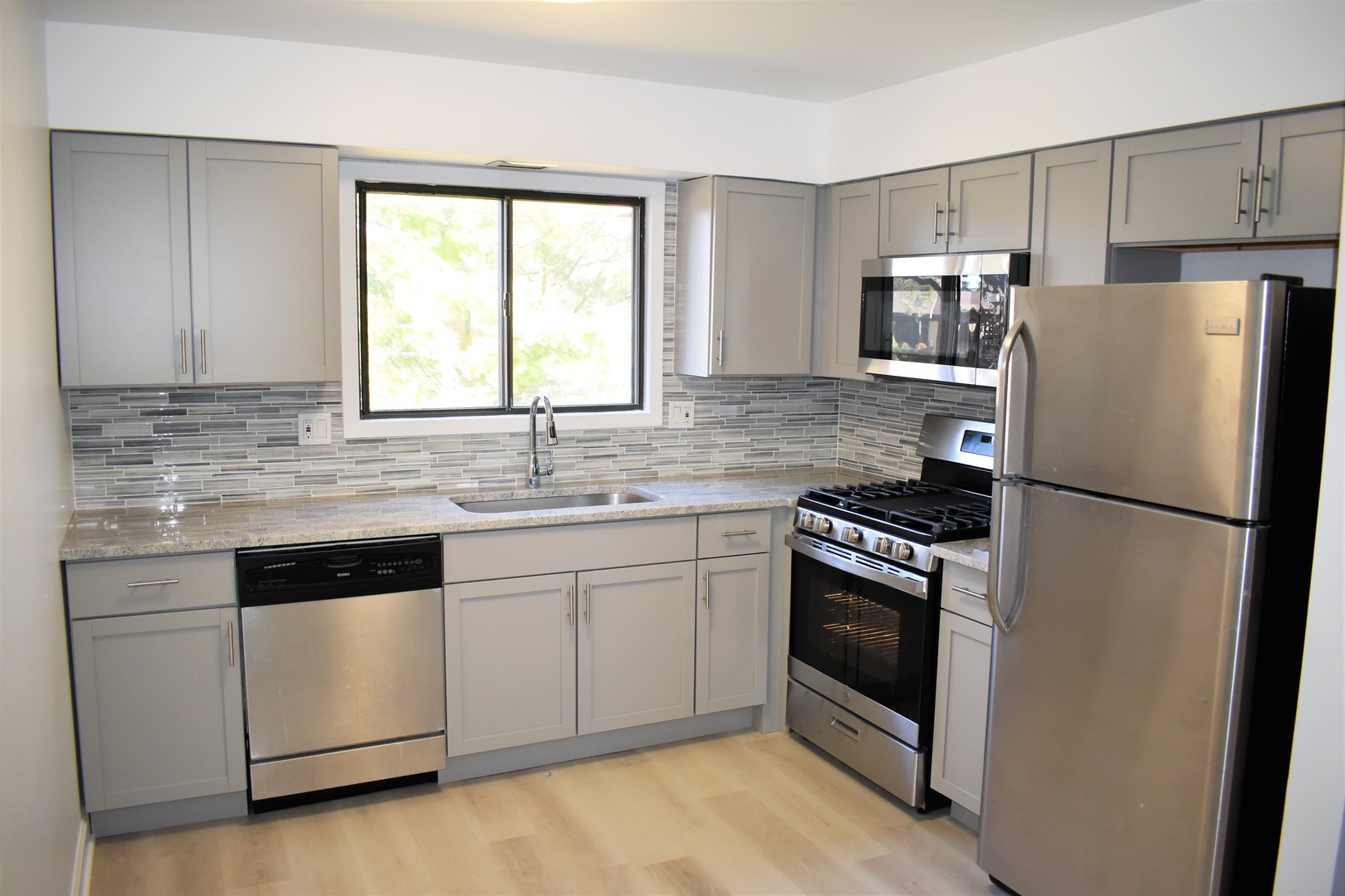 1741 Harrow Court, Unit B Wheaton, IL 60189 - Photo 3 of 24 a kitchen with granite countertop white cabinets and white appliances