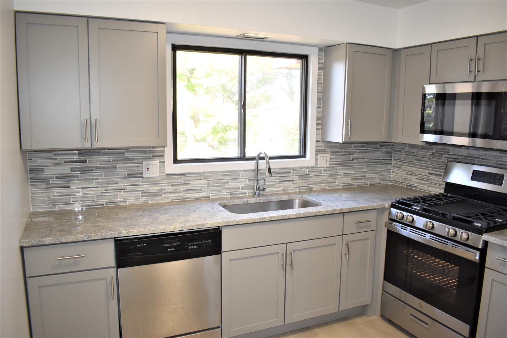 1741 Harrow Court, Unit B Wheaton, IL 60189 - Photo 8 of 24 a kitchen with granite countertop a sink cabinets stainless steel appliances and a window