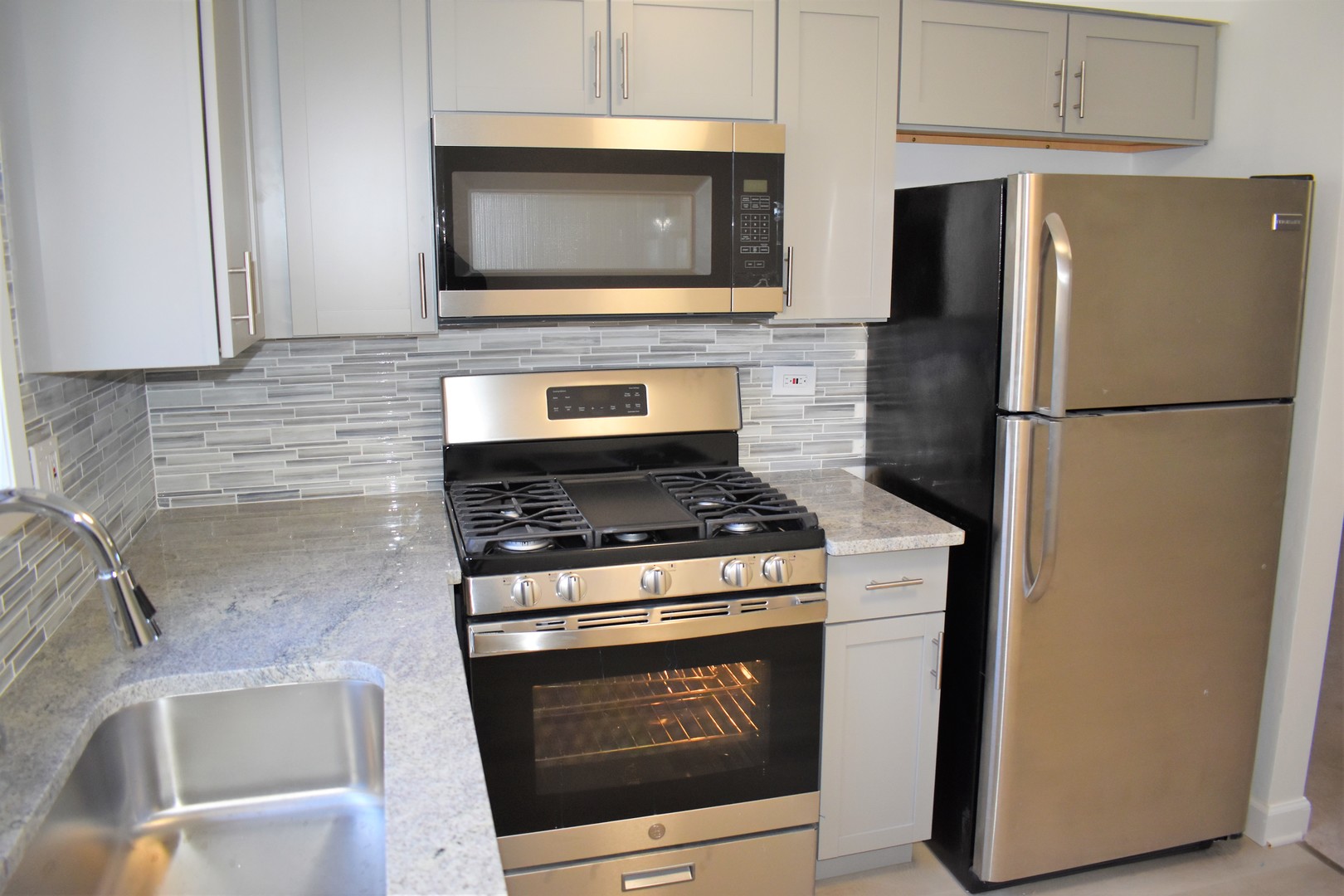 1741 Harrow Court, Unit B Wheaton, IL 60189 - Photo 9 of 24 a kitchen with stainless steel appliances wooden cabinets stove and microwave