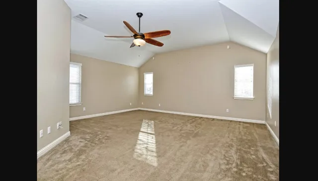 an empty room with windows and fan