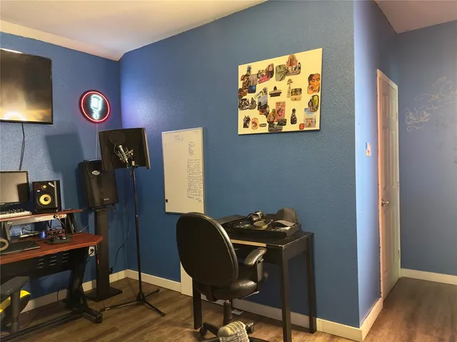 a view of workspace with wooden wall paintings a flat screen tv and a lamp