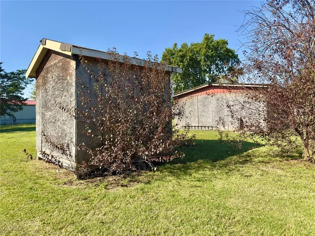 a view of a wooden house with a yard
