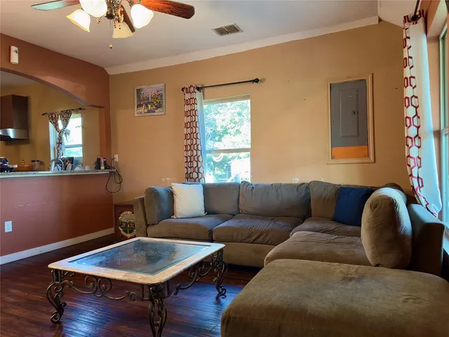a living room with furniture and a wooden floor