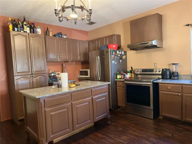 a kitchen with a sink refrigerator and microwave