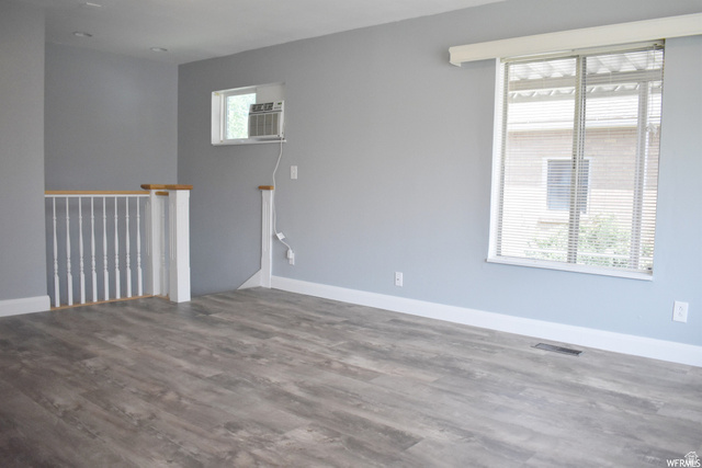 490 Averett Avenue Springville, UT 84663 - Photo 13 of 14 Spacious room featuring wood-finish flooring, light grey walls, white baseboards, and a large window with horizontal blinds