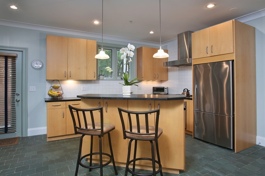 a kitchen with stainless steel appliances granite countertop a refrigerator a microwave a stove and white cabinets