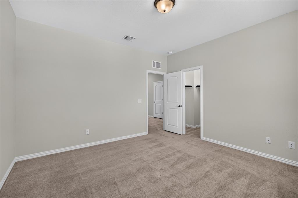 8715 Royal Star Road Rowlett, TX 75089 - Photo 32 of 39 Plush carpeting and light gray wall tones create a neutral palette