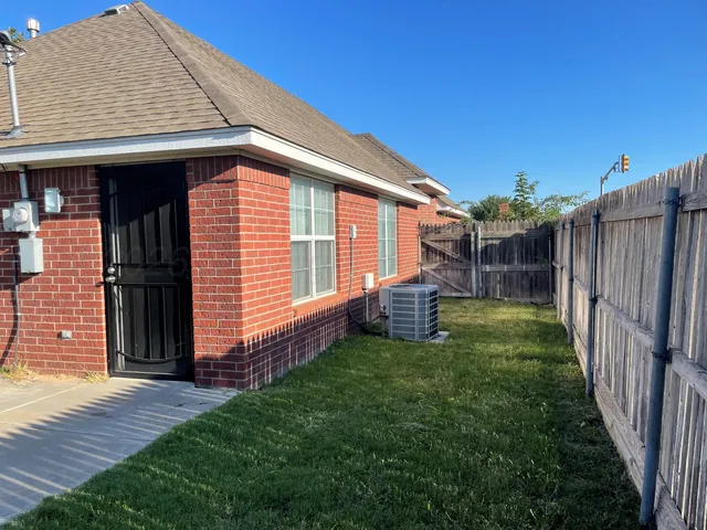 a view of backyard with barbeque grill and wooden fence