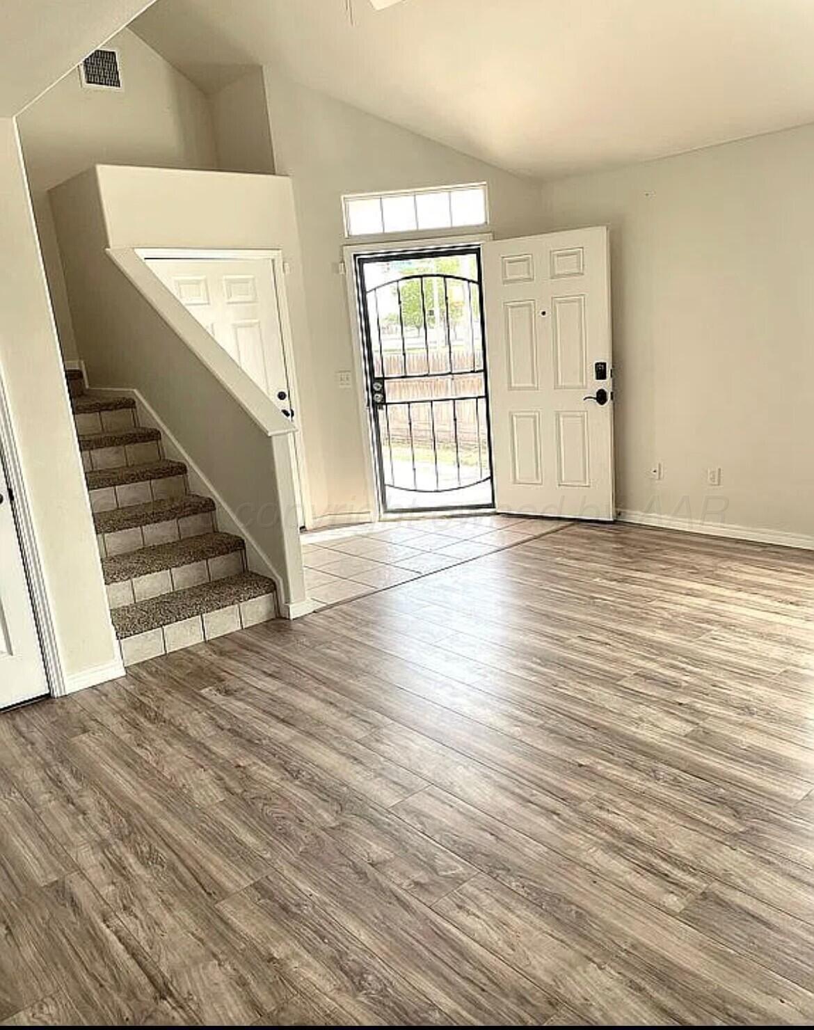 6001 Estacado Lane Amarillo, TX 79109 - Photo 4 of 21 a view of an empty room with wooden floor and a window