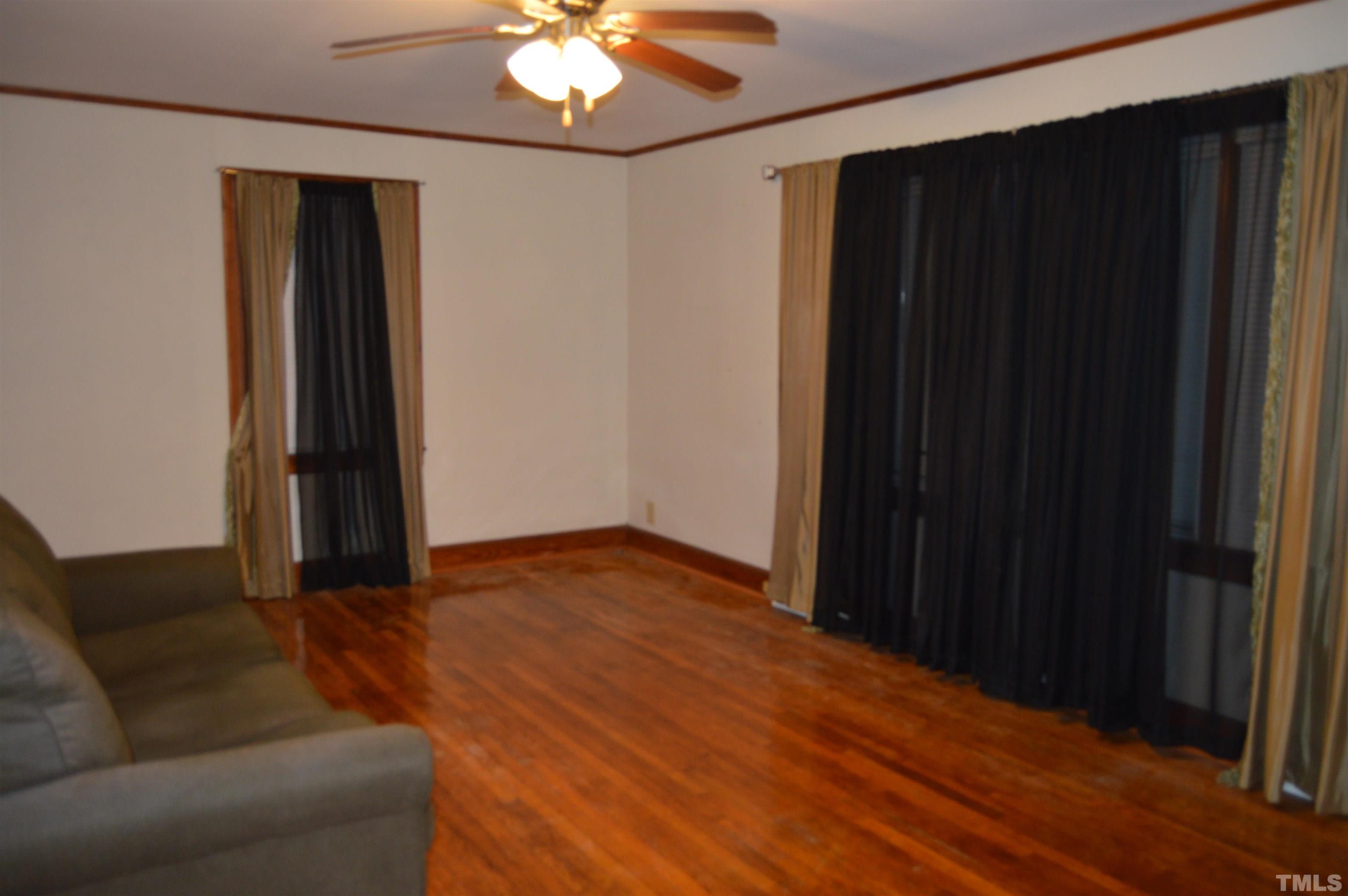 853 Lucy Garrett Road Roxboro, NC 27574 - Photo 7 of 9 a living room with hardwood floor and a ceiling fan