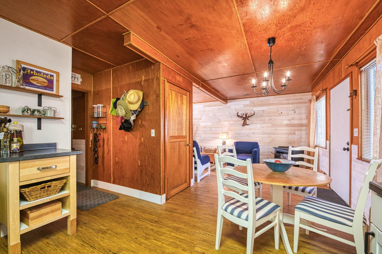 61347 Old Hunting Road Mono Hot Springs, CA 93634 - Photo 12 of 31 a view of a dining room with furniture a chandelier and wooden floor