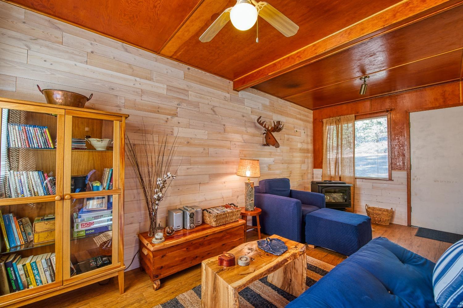 61347 Old Hunting Road Mono Hot Springs, CA 93634 - Photo 7 of 31 a living room with furniture a bookshelf and a window