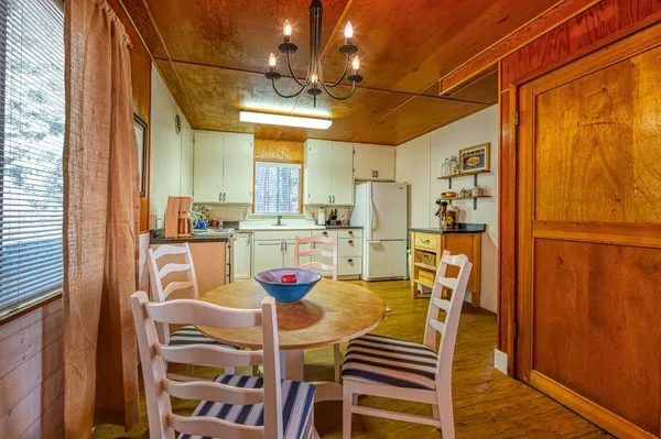 a view of a dining room with furniture a chandelier and wooden floor