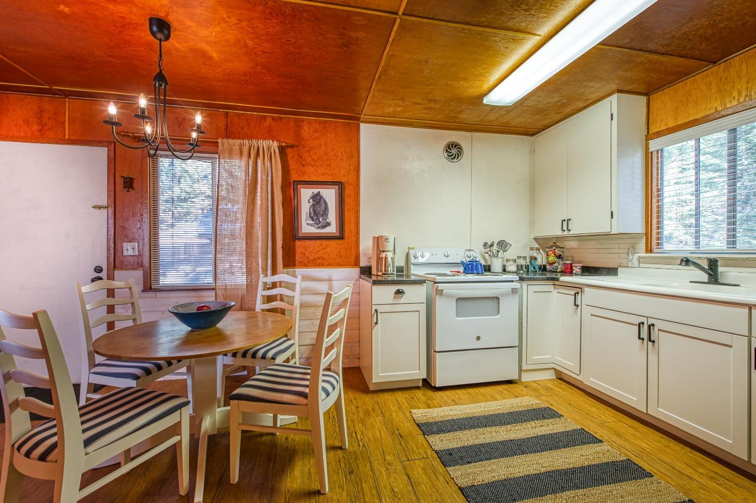 61347 Old Hunting Road Mono Hot Springs, CA 93634 - Photo 10 of 31 a kitchen with a dining table chairs and white appliances