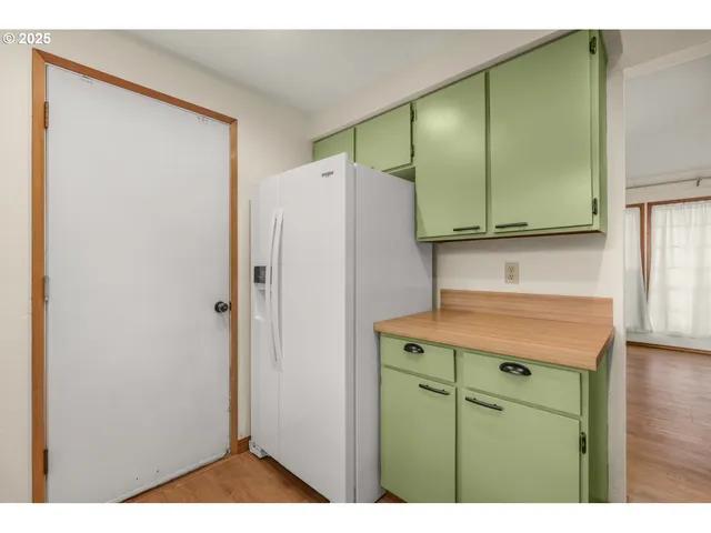 a kitchen with cabinets and a refrigerator