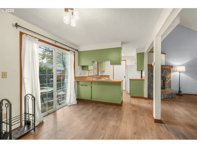 a view of empty room with a fireplace and wooden floor