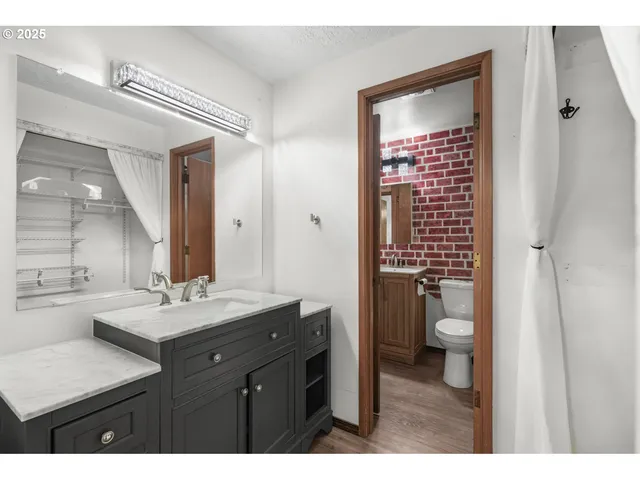 a bathroom with a sink toilet double vanity and shower
