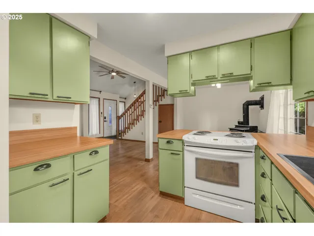 a kitchen with cabinets and wooden floors