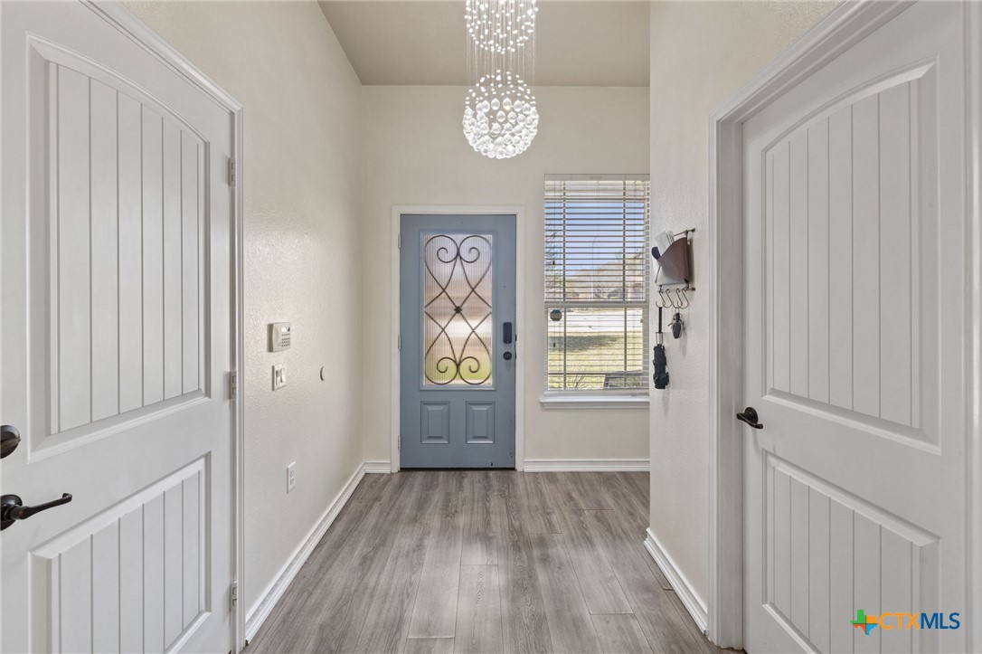 10113 Copper Ridge Cove Austin, TX 78747 - Photo 4 of 32 a view of a hallway with wooden floor and a window