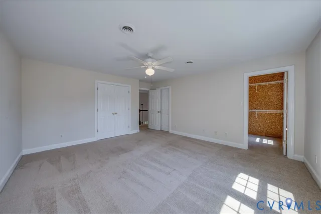 an empty room with a ceiling fan and a window
