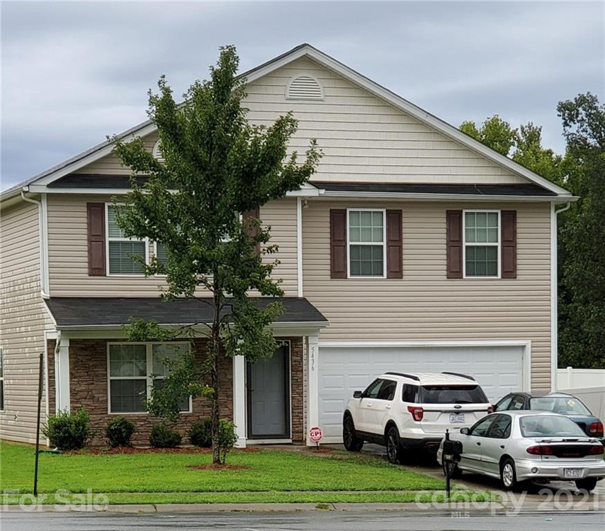 a couple of cars parked in front of a house