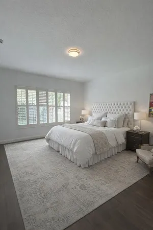 a bedroom with a bed and a large window