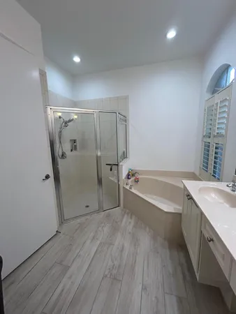 a bathroom with a tub shower vanity and a sink