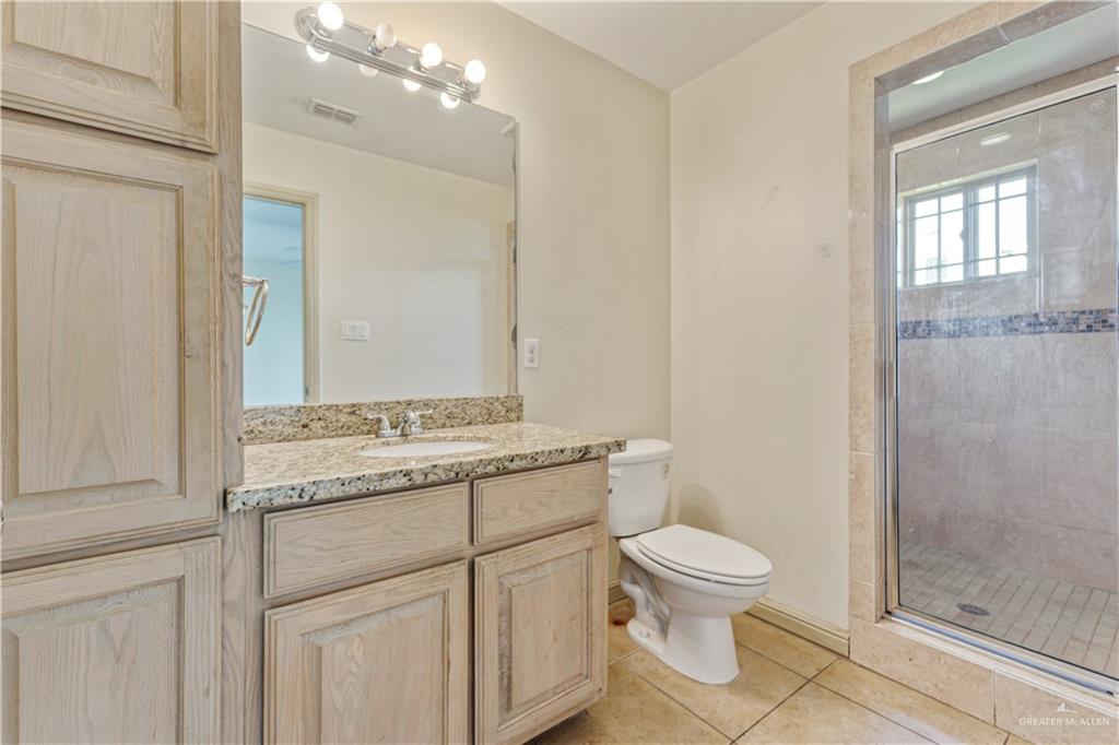 1500 Humming Bird Court, Unit 15 Pharr, TX 78577 - Photo 11 of 26 a bathroom with a granite countertop toilet a sink and a mirror