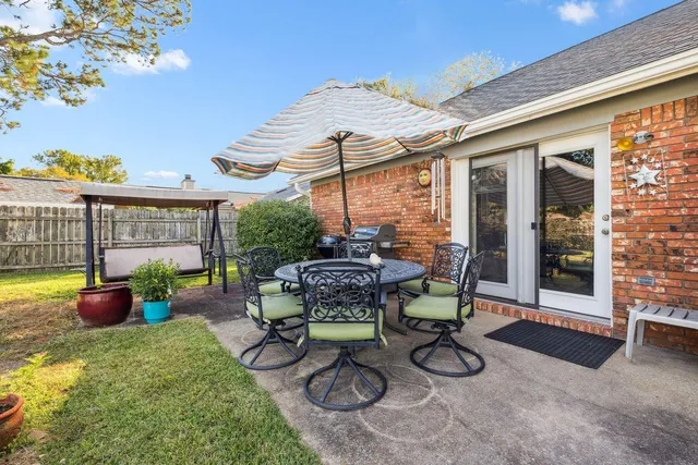 a view of a patio with table and chairs potted plants with wooden floor and fence