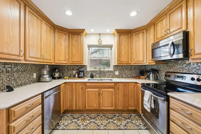 a kitchen with stainless steel appliances granite countertop a stove a sink dishwasher and a microwave